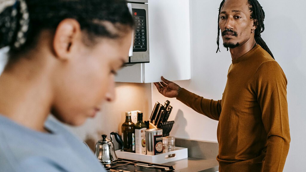 Women looking down with man in kitchen
