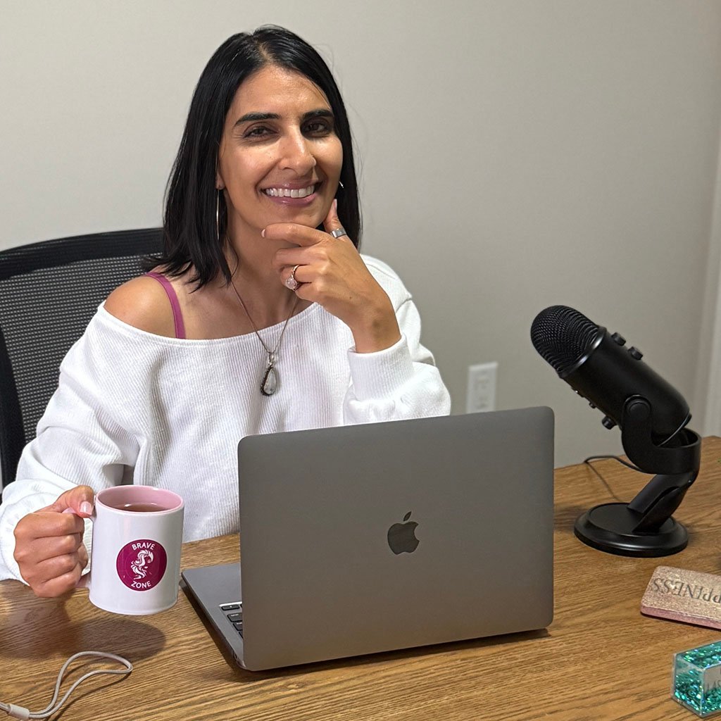 The Bravezone Experience with Nadia the CEO holding a mug infront of a laptop while smiling