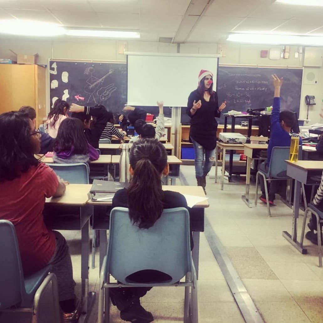 Nadia in a classroom with a red nose