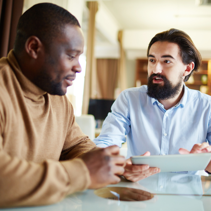 Two people discussing with a tablet.